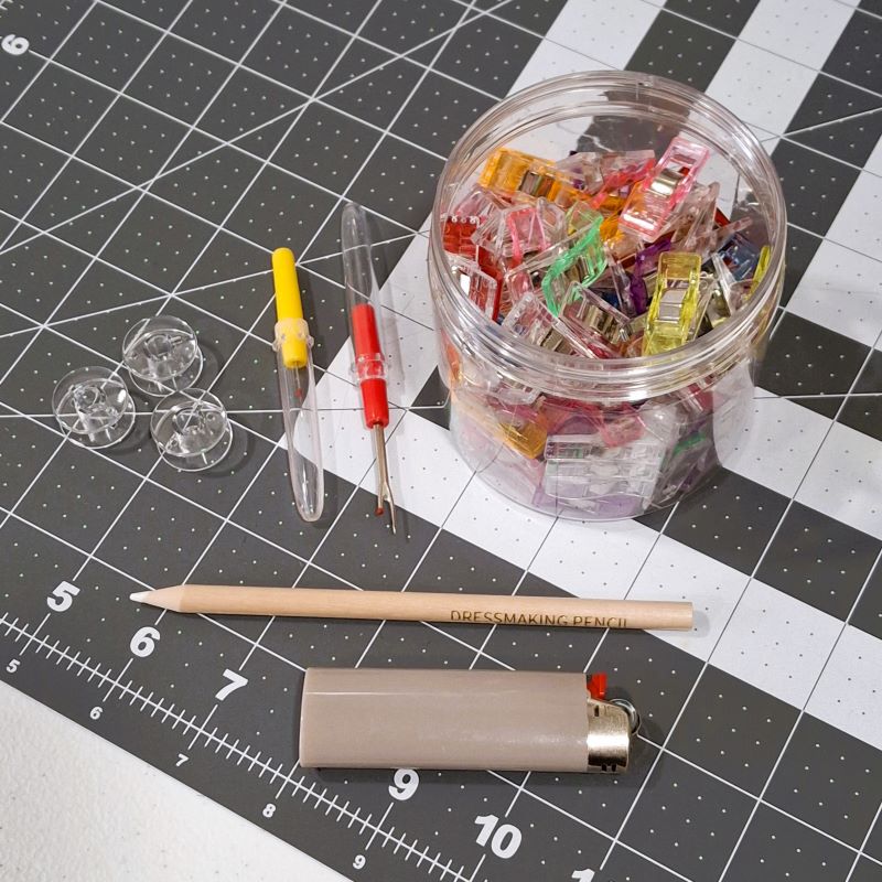 Sewing accessories like seam rippers, sewing clips, sewing pencil, and bobbins
