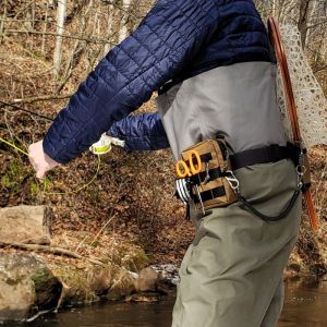 Fly fisher with a small fly fishing pack on his belt. 