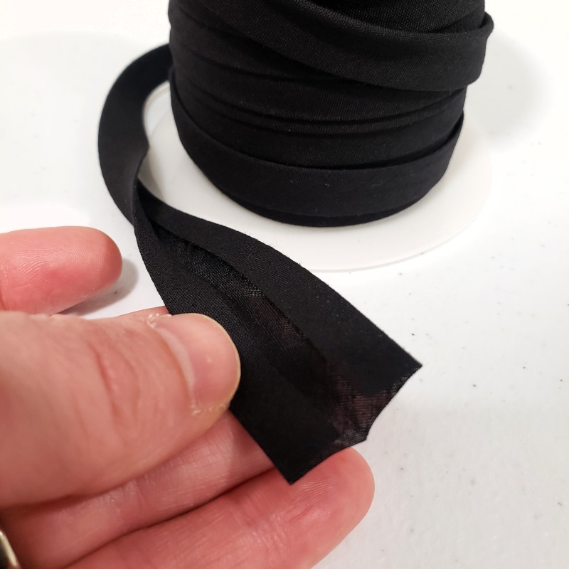 Double-fold bias tape being separated to show the folds