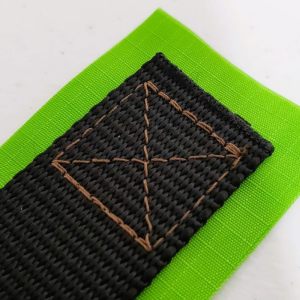 A finished box X stitch, connecting a webbing strap to fabric.